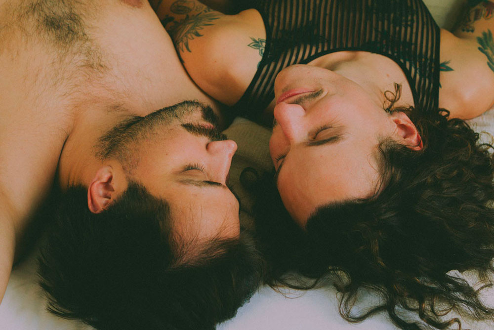 Hommes en couple dans un lit détendus, relaxés