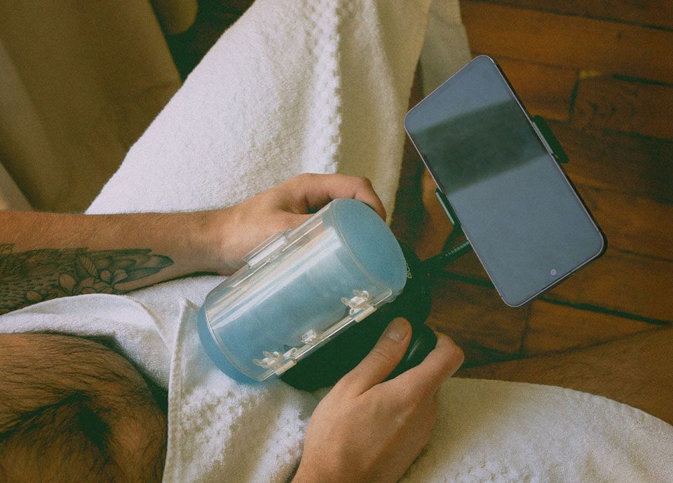 Homme qui tient un masturbateur automatique avec téléphone dessus